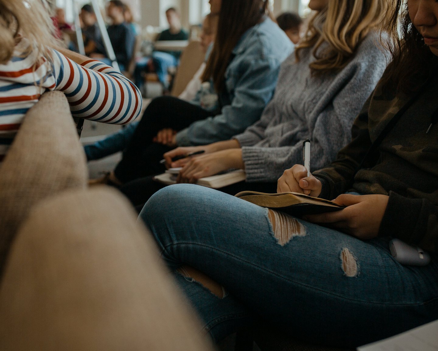 Student writes in a notebook during a group study session.